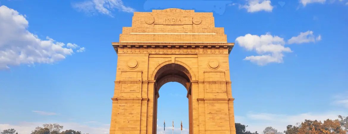 India Gate monument in New Delhi under a bright blue sky.